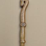 #164 A stick 190 cm high with an goat head and wood carving